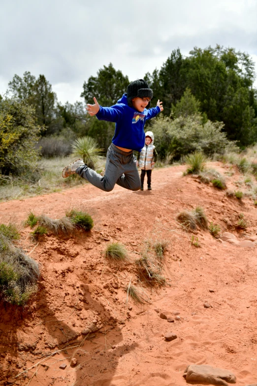 a person is running over a hill by some trees