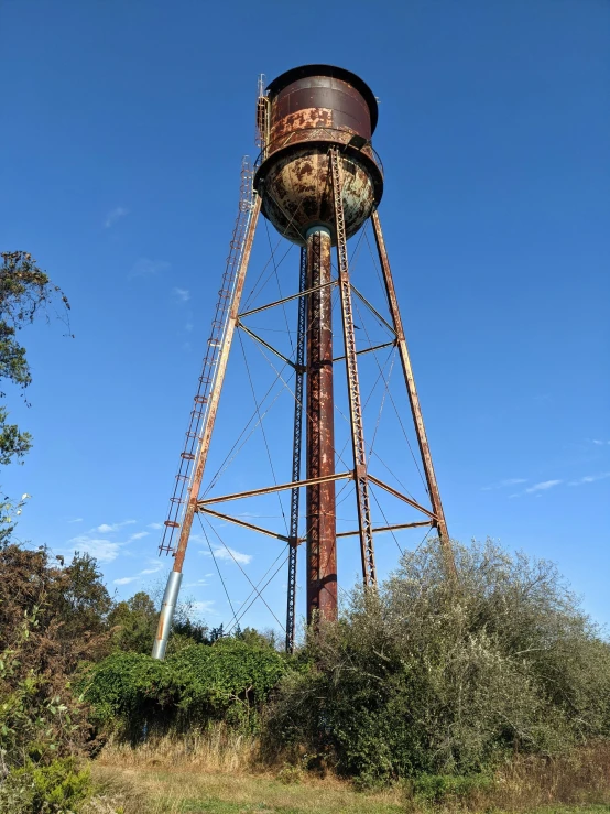 an old water tower sitting in the middle of the wild