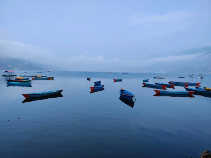 the boats are parked along a shoreline in calm water