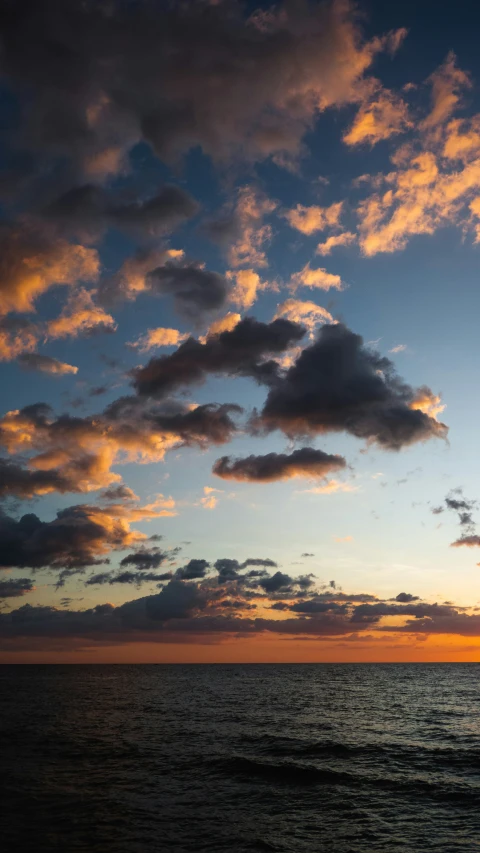 the sun setting on the horizon of the ocean