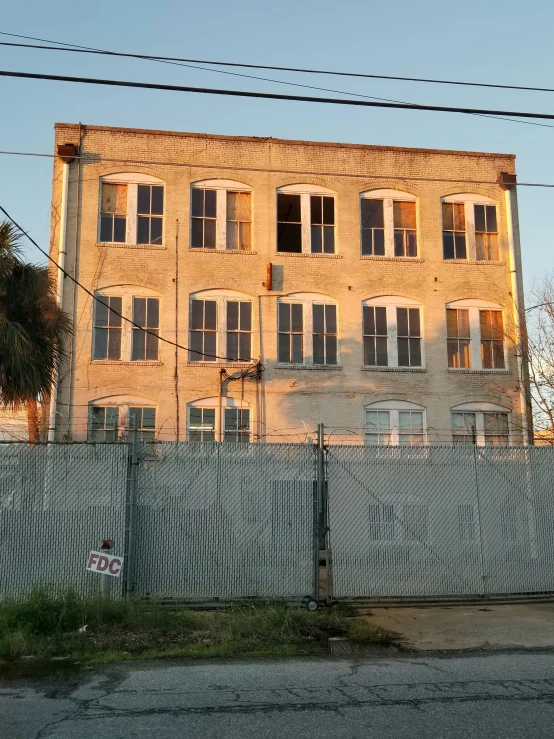 a very big old run down building by some fences