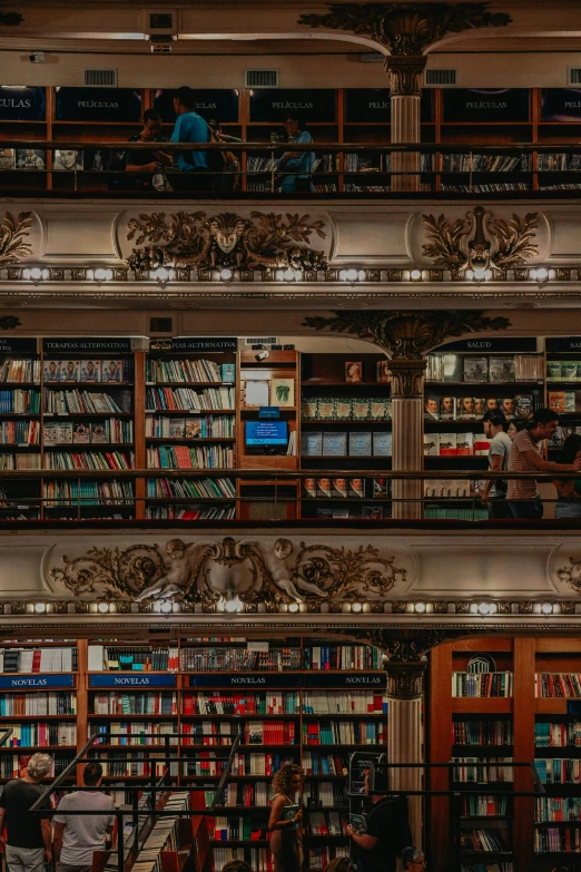 several people sitting in a bookstore full of books