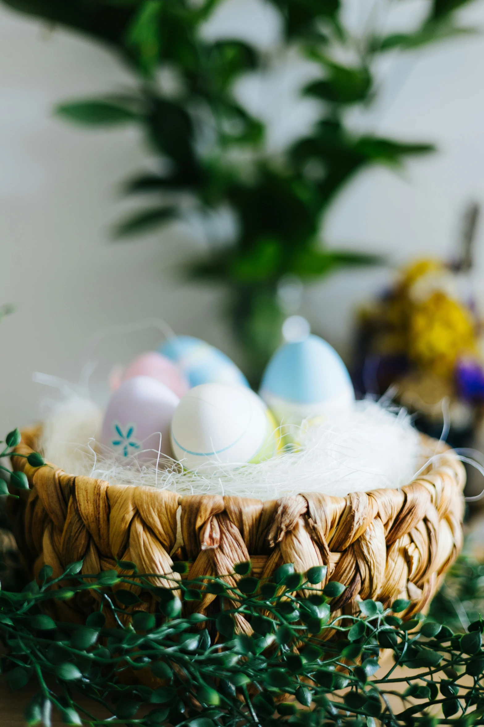 a basket filled with small white and blue decorated eggs