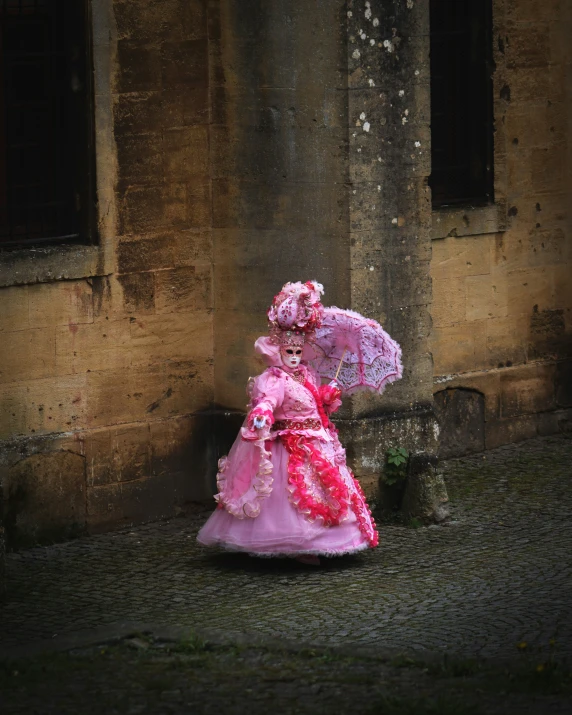 a lady wearing an ornately decorated dress and large pink hat