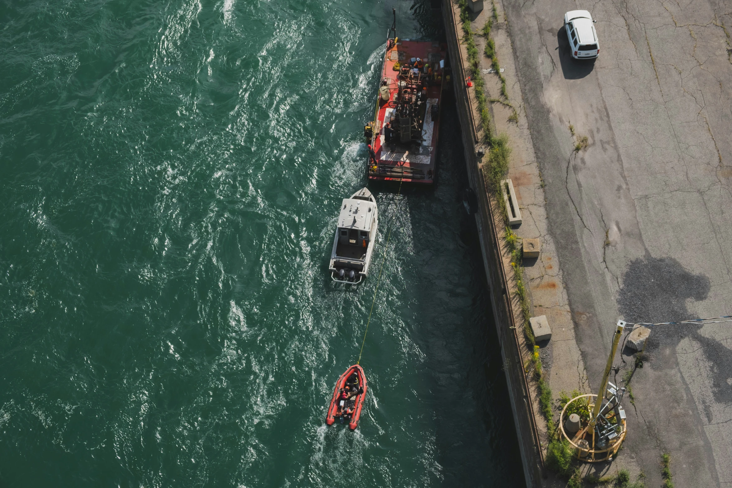 two boats floating next to a cement bridge