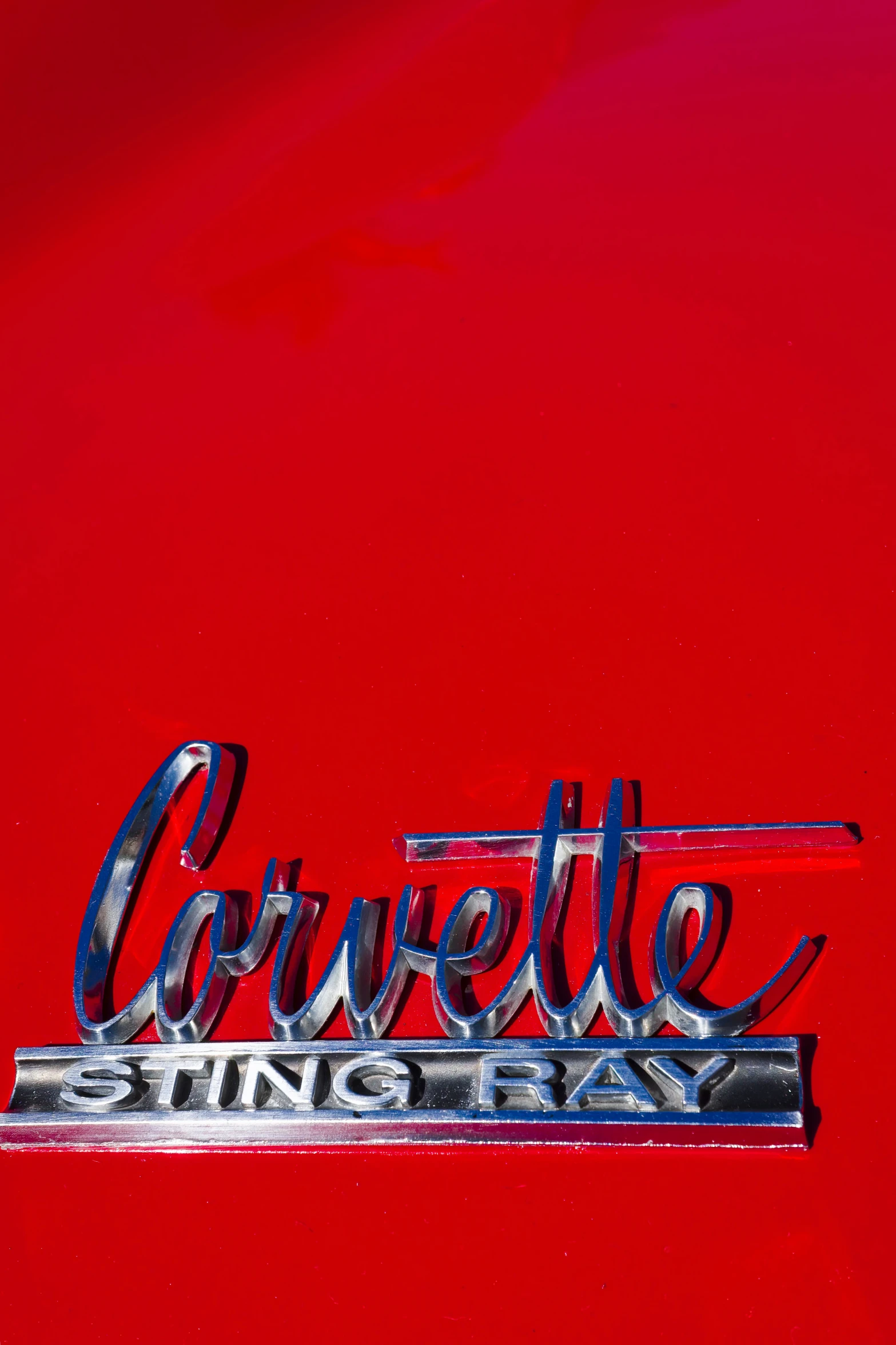 corvette sting ray emblem on a shiny red car