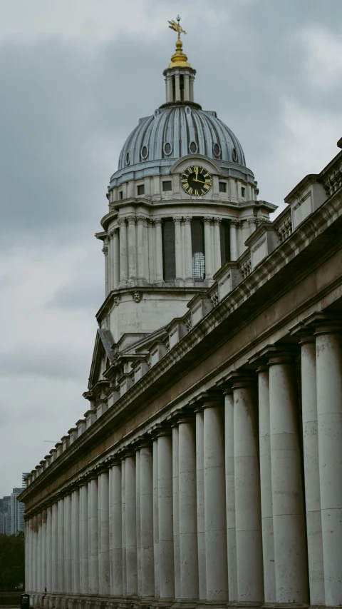 the building has white pillars and gold dome on top