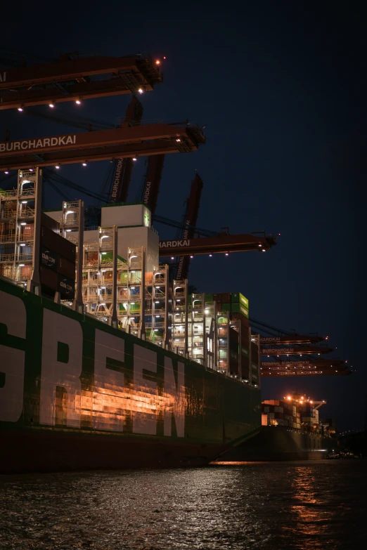 a big cargo ship in a harbor at night