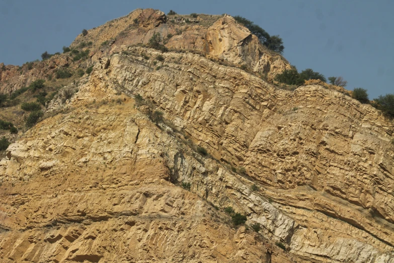 the steep rocky landscape has trees growing on it