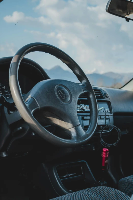 a closeup s of the steering wheel and dash stick in a car