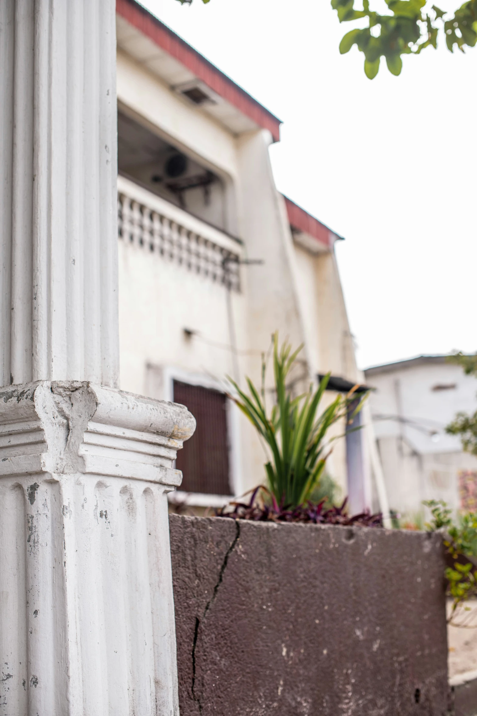 a tall white pillar sitting next to a brick wall