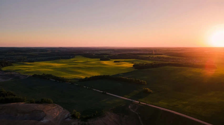 a very bright sunset on some green land