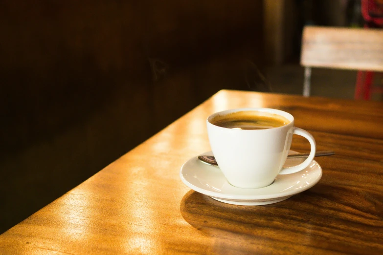 a cup filled with liquid on top of a wooden table