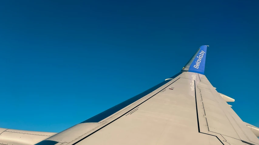 the view from below a plane wing against the blue sky