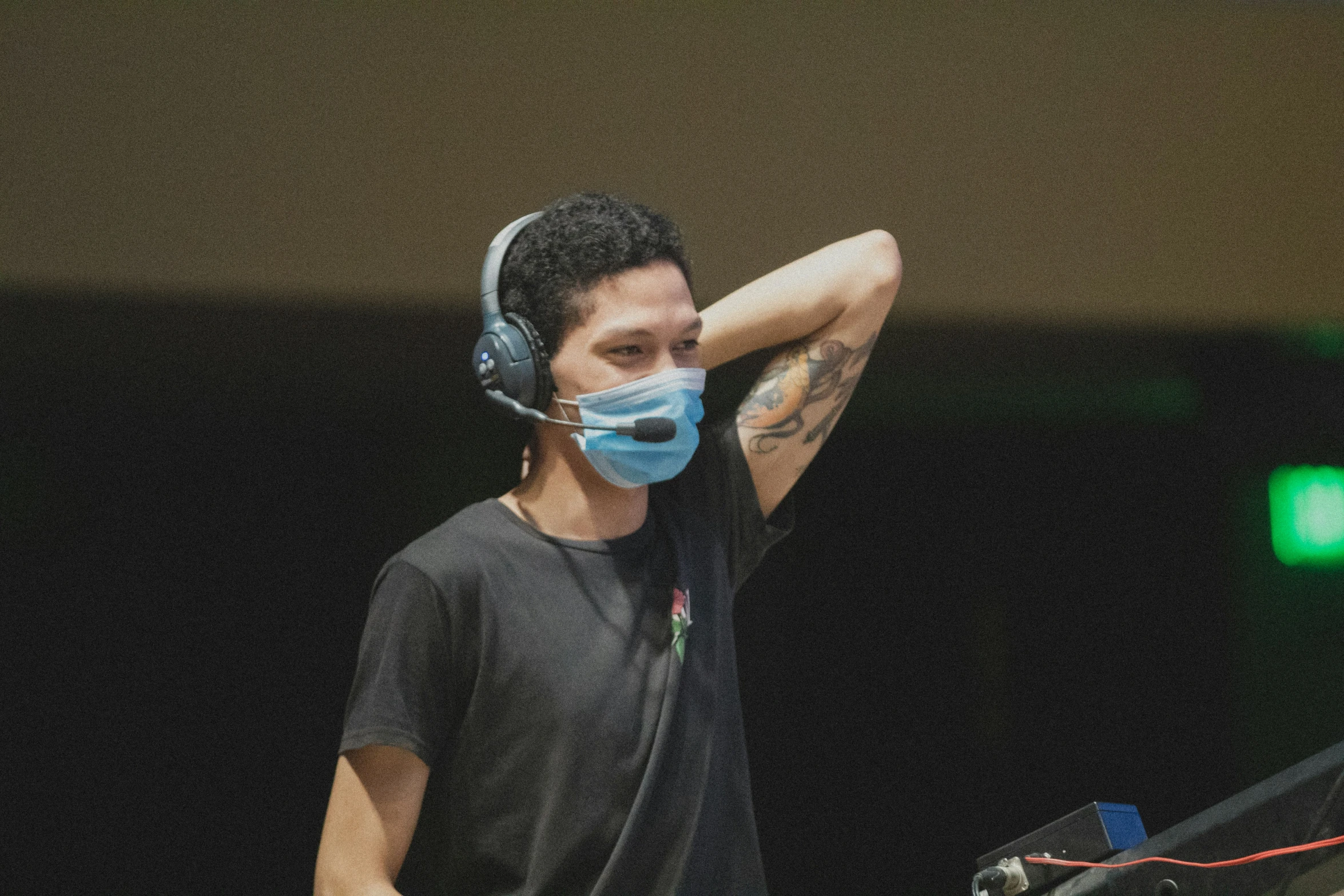 a man wearing a face mask and playing dj equipment