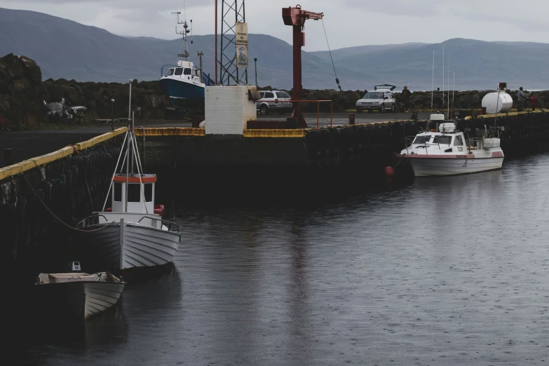 boats are docked at a pier at the shore