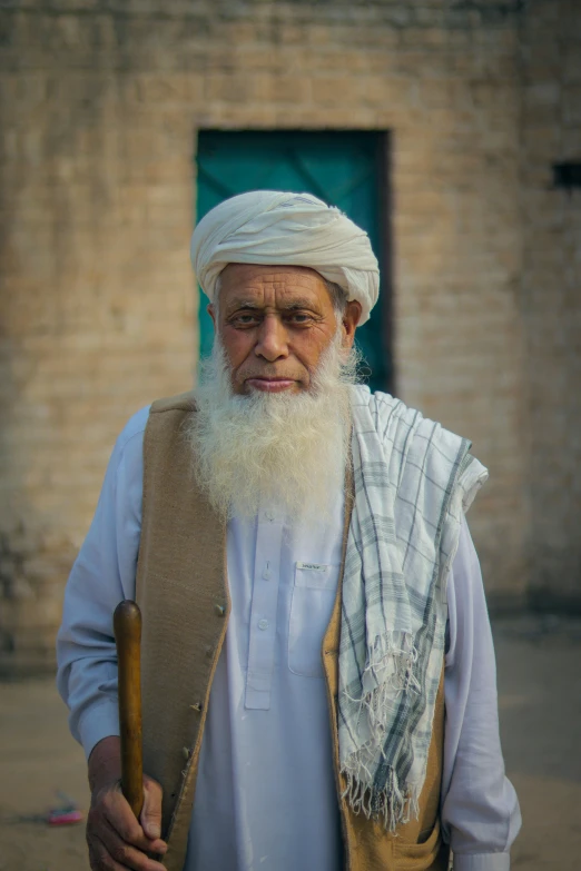 an old man with long white beard holding a wooden stick