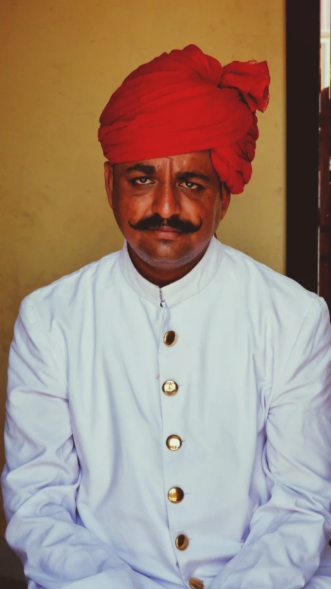 a man with a mustache wearing a turban