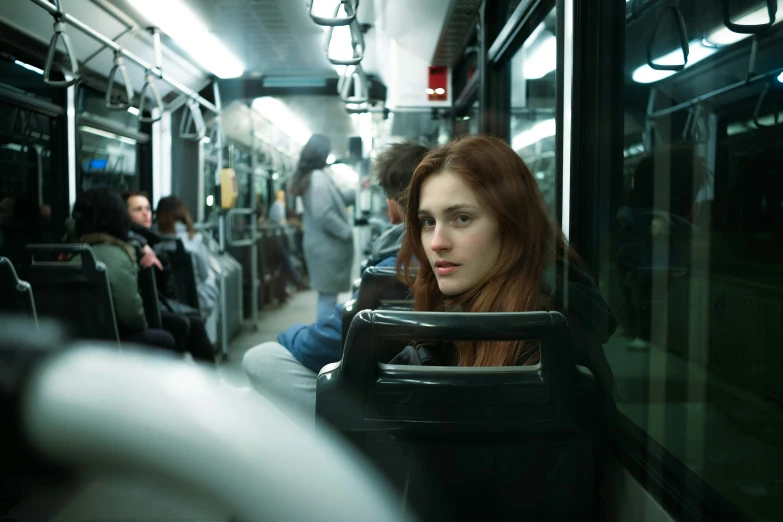 a woman sitting next to a window on a subway