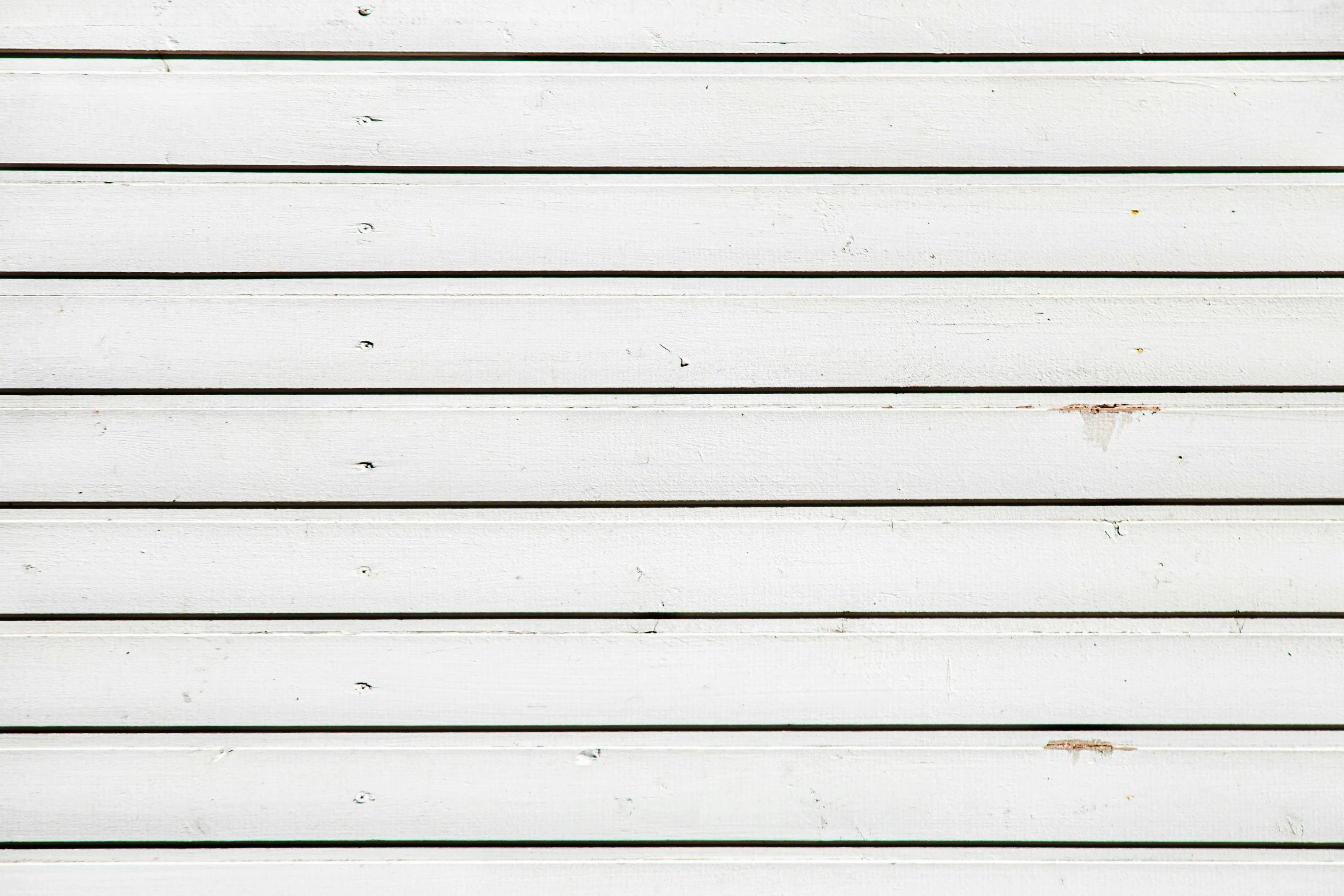 a black bird sitting on top of the wooden wall