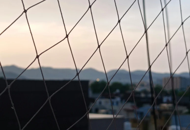 view of some buildings from a chain link fence