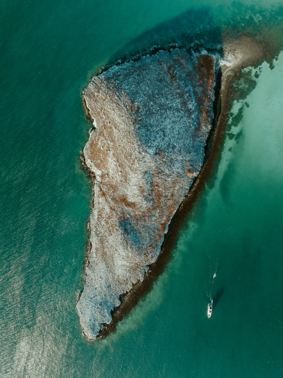 an aerial view of two surfers in the water