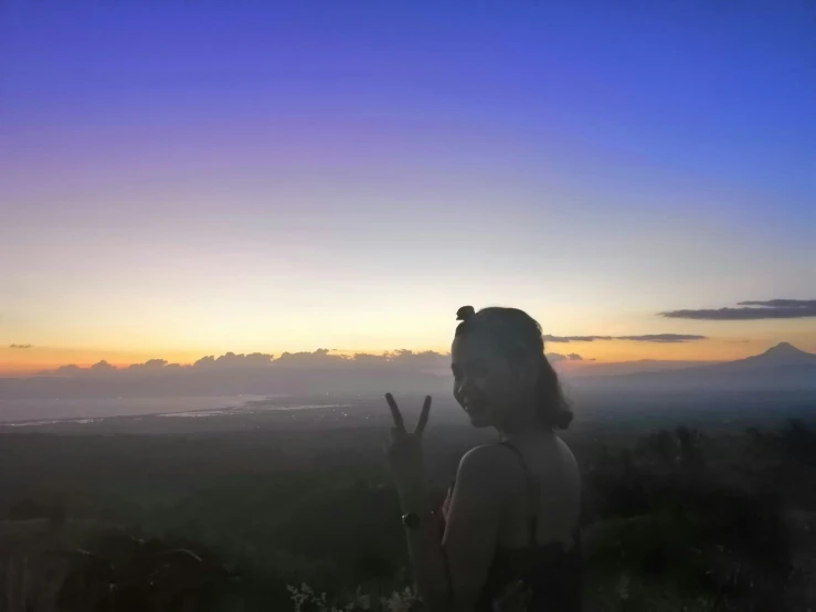 a person in the distance making the peace sign