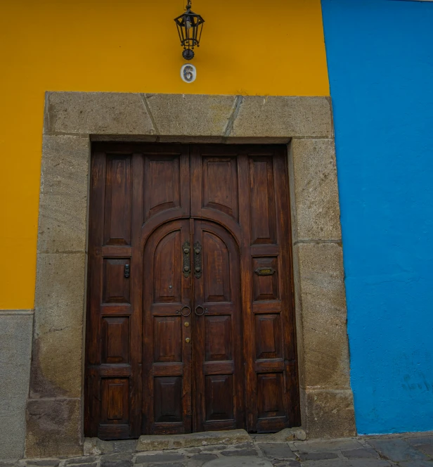 a large brown doorway is up against a colorful wall