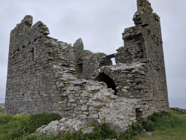 an old, dilapidated castle with a big stone wall