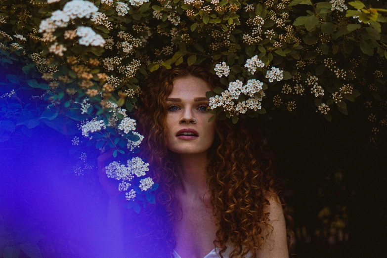 a woman with curly hair wearing a white shirt