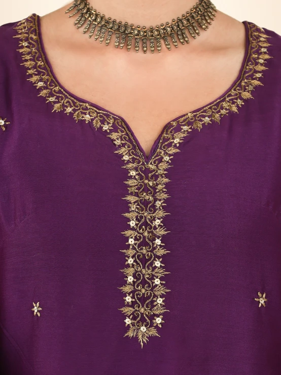 a woman with a purple dress and a gold necklace