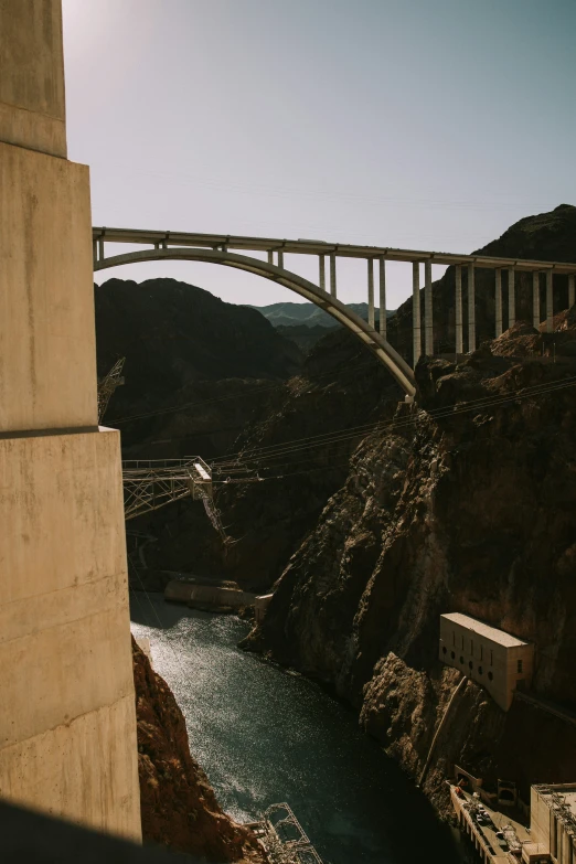 a bridge over some water next to the hills