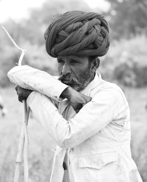 a black and white po shows an indian man holding a bird