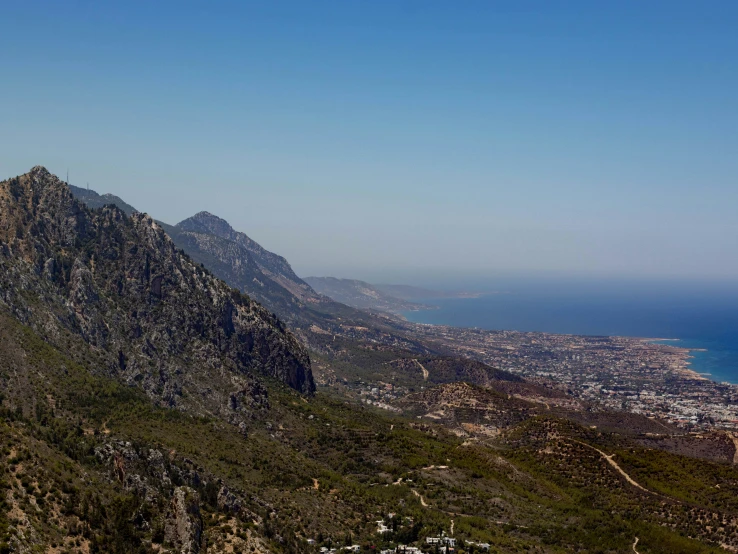 the mountains are overlooking the sea and a city