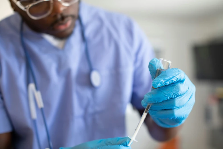 doctor with blue gloves and stethoscope taking a sample