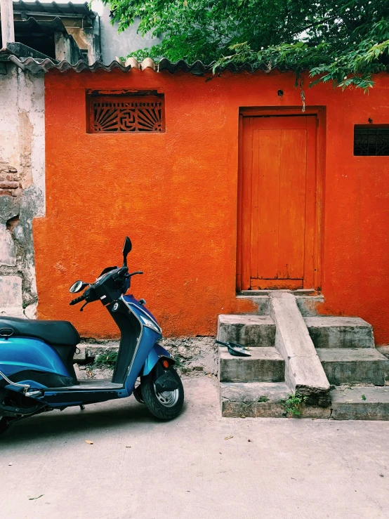 a moped is parked in front of a small building