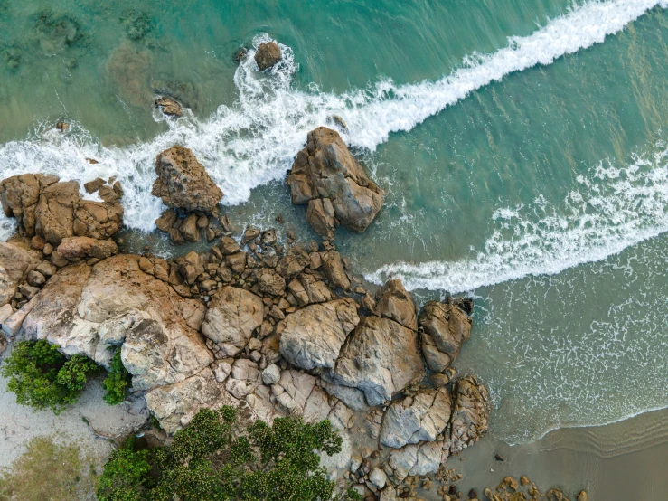 a view of a beach with rocky coast and surf