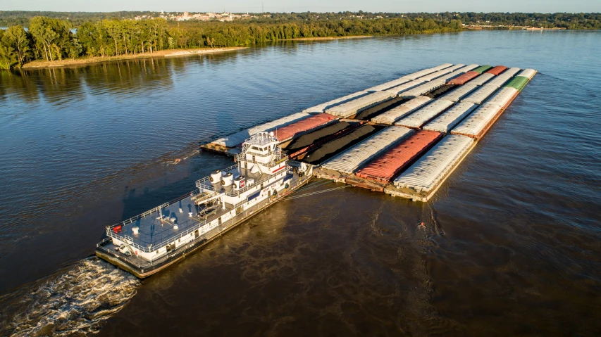 an aerial view of a barge carrying cargo on water