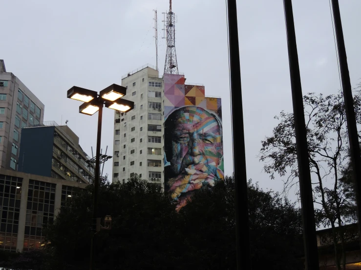 large mural on the side of tall buildings at dusk