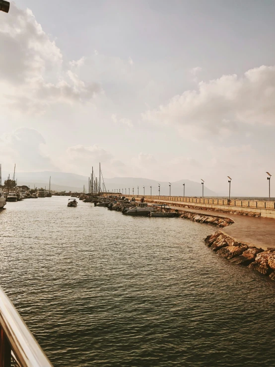 an empty pier in the water at the end of the sidewalk