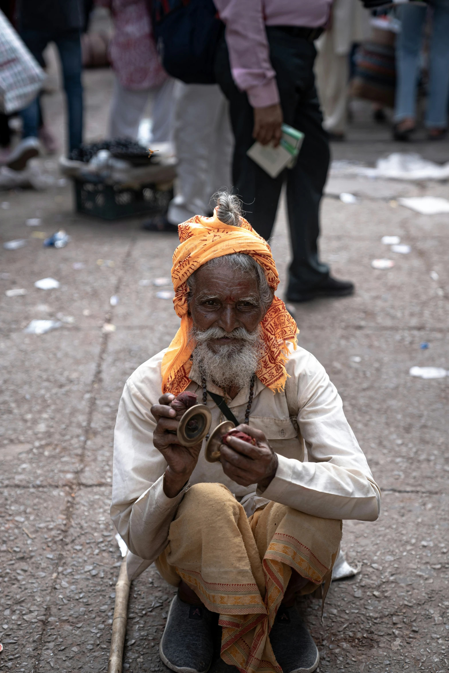 an old man with orange beard and orange hair sits on the street and talks on his phone