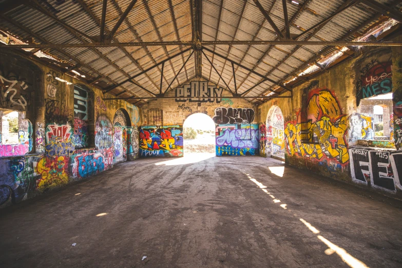 a warehouse with graffiti all over the walls and on the ground