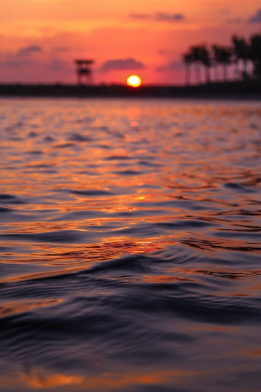 the sunset over the calm water of a lake