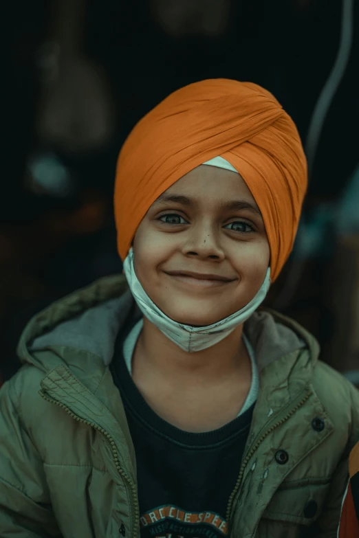 a  wearing an orange turban smiles for the camera