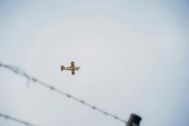 an airplane flying in the sky with power lines