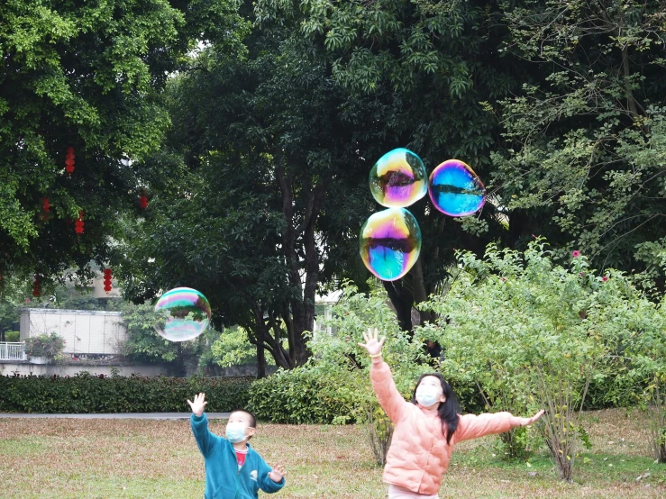 people playing with soap bubbles on a city street