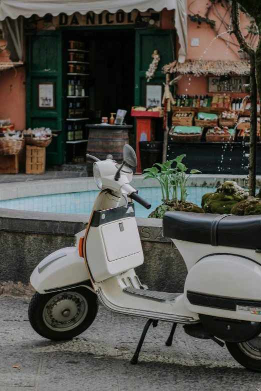 a scooter is parked on the street near a fountain