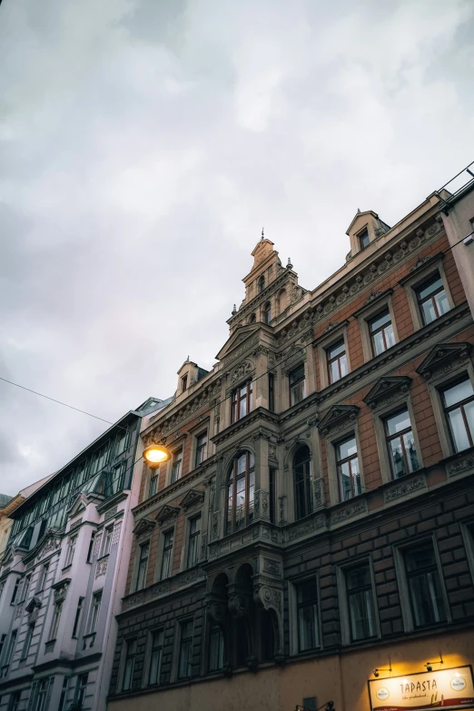 a tall building with lots of windows against a cloudy sky