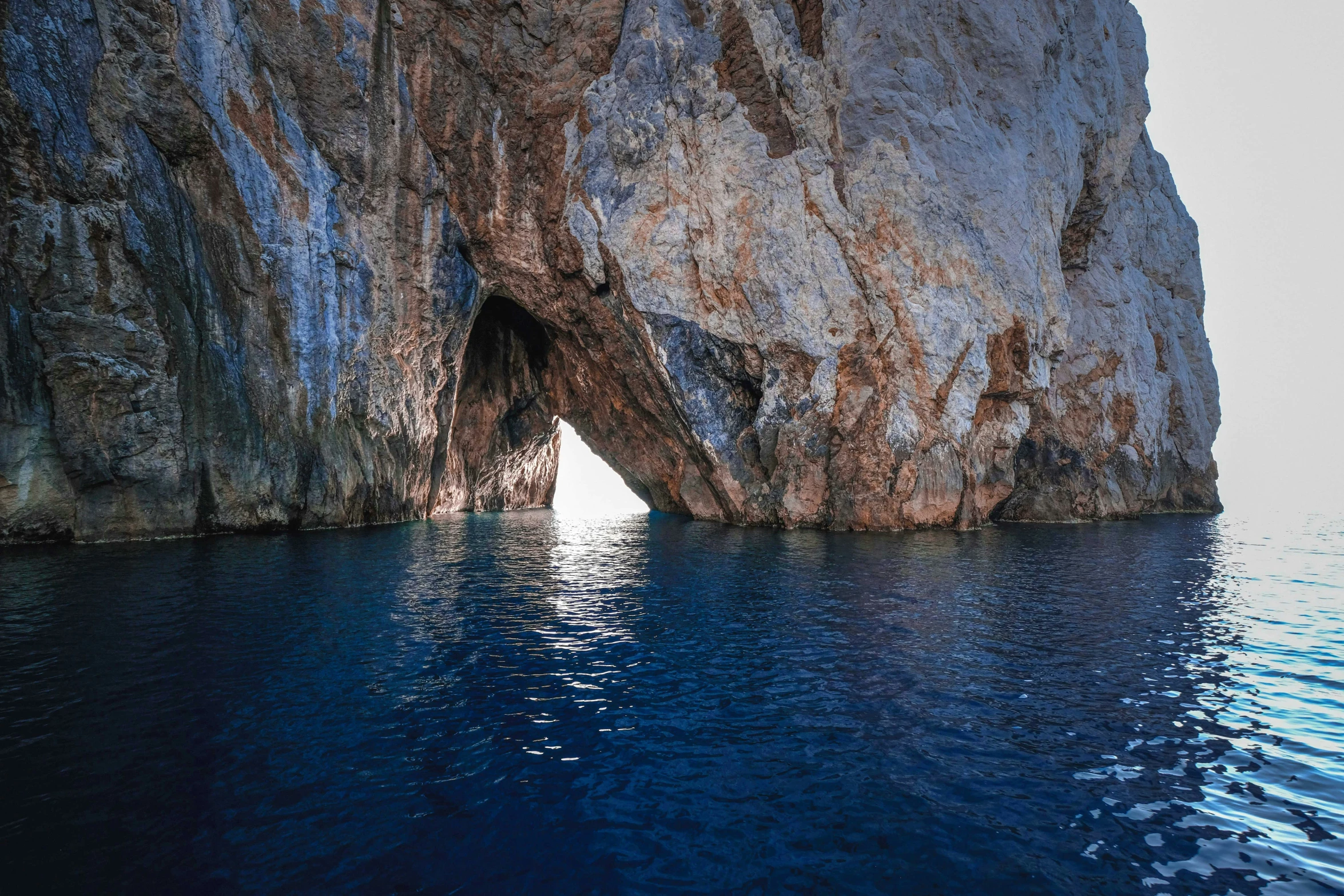 an abstract s of a rock cave with water below