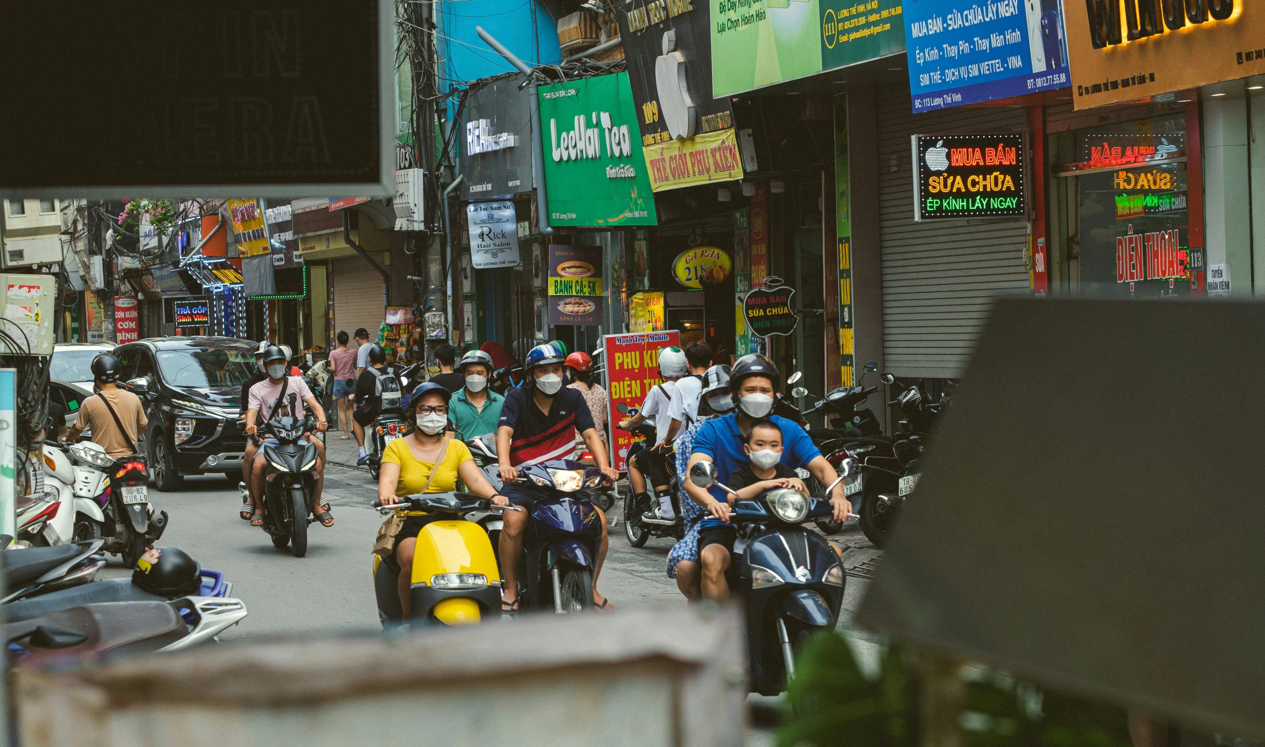 people riding motorcycles and scooters on a busy street